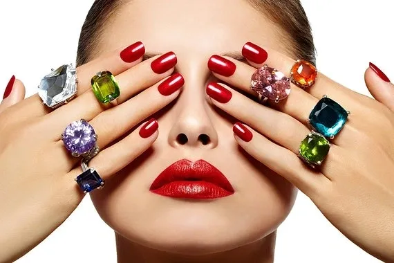Red manicure and gemstone rings
