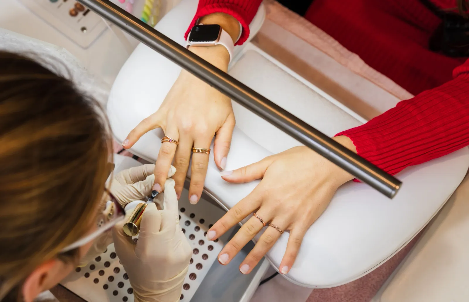 Nail artist applying polish during a manicure